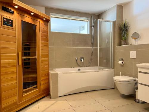 a bathroom with a shower and a tub and a toilet at Ferienwohnung Schlei & Meer Olpenitz in Olpenitz