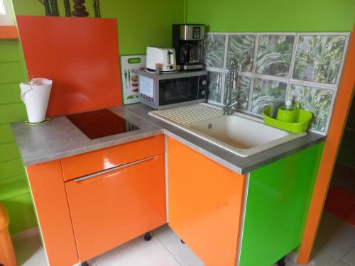 Il comprend une petite cuisine équipée d'un évier et d'un four micro-ondes. dans l'établissement Fatou location, à Petit-Bourg