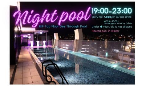 un cartel que dice piscina nocturna en un edificio en Hotel Aqua Citta Naha, en Naha