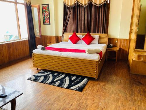 um quarto com uma cama com almofadas vermelhas em Jamshi Guest House em Rajkot