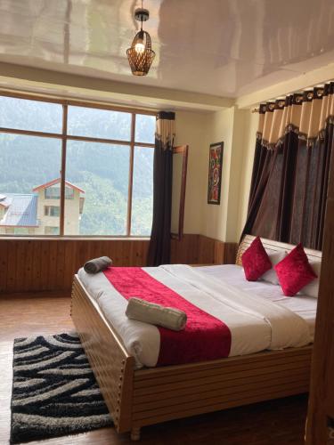 um quarto com uma cama e uma janela grande em Jamshi Guest House em Rajkot