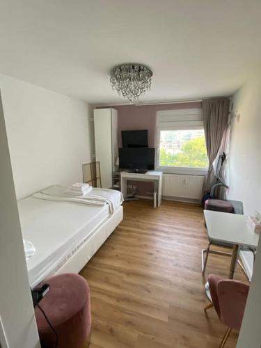 um quarto com uma cama e cadeiras e uma janela em Schöne, kleine, gemütliche Wohnung - Stadtmitte em Mainz
