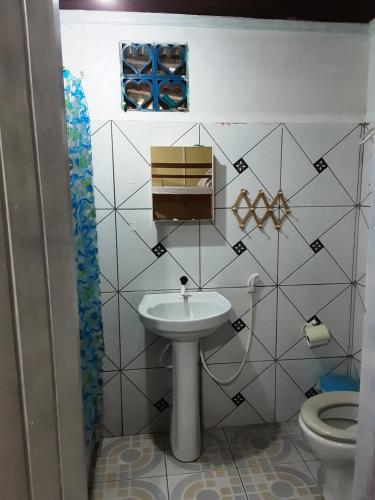 a bathroom with a sink and a toilet at Albergue Flor do Caribe in Parintins