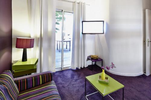 a living room with a couch and a table at Maison d'hôtes Bordeaux Centre Le Patio de l'Intendance in Bordeaux
