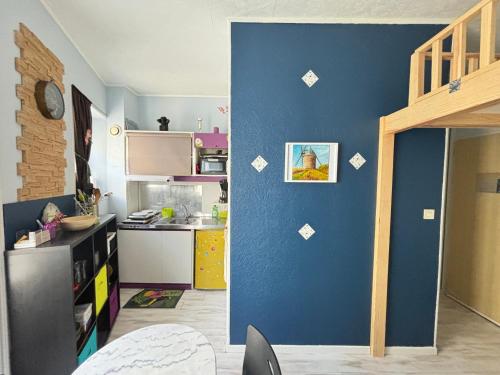 une cuisine avec un mur bleu avec des autocollants dessus dans l'établissement Studio Centre-ville, 100m Plage, Confort et Praticité - FR-1-197-378, à Les Sables-dʼOlonne