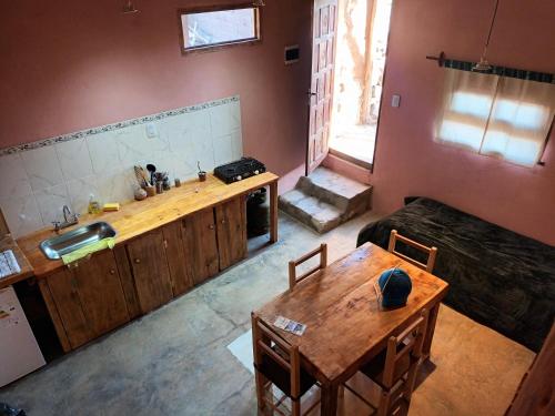 a living room with a table and a kitchen at Reposo del Huasamayo in Tilcara