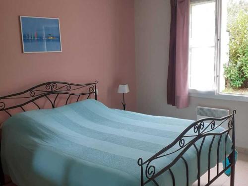 - une chambre avec un lit doté d'une couverture bleue et d'une fenêtre dans l'établissement Maison La Tranche-sur-Mer, 5 pièces, 6 personnes - FR-1-476-77, à La Tranche-sur-Mer
