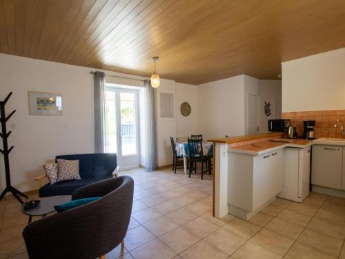 une cuisine et un salon avec un canapé et une table dans l'établissement Maison charmante avec cour, WIFI, proche de Sarlat, idéale famille, équipements bébé inclus - FR-1-616-193, à Calviac