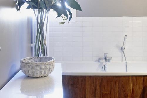 a bathroom with a sink and a vase with a plant at Maison d'hôtes Bordeaux Centre Le Patio de l'Intendance in Bordeaux