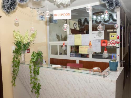 a restaurant with a counter with plants on it at Hotel El Ejido in Quito