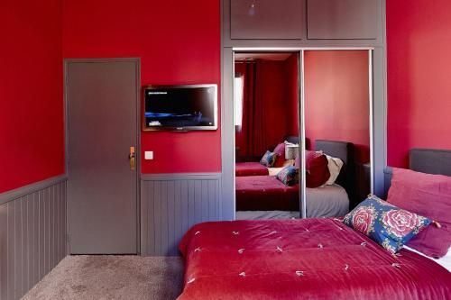 a bedroom with red walls and a bed and a mirror at Maison d'hôtes Bordeaux Centre Le Patio de l'Intendance in Bordeaux