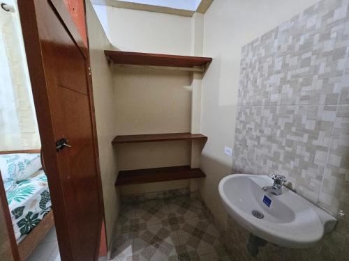 ein kleines Bad mit einem Waschbecken und einem WC in der Unterkunft Hostal Beru in Puerto Nariño