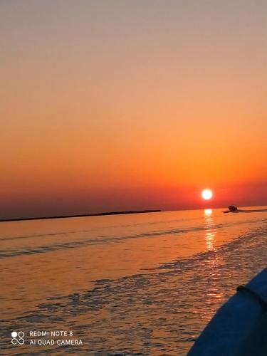 a sunset on the ocean with the sun setting at Casa aloha-Isla Holbox in Holbox Island