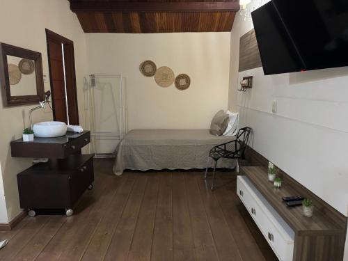 a room with a bed and a sink in it at Chalé 06 com hidro in Itatiaia