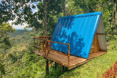 een hut in het bos met een blauw dak bij Tierras Munay in El Doncello
