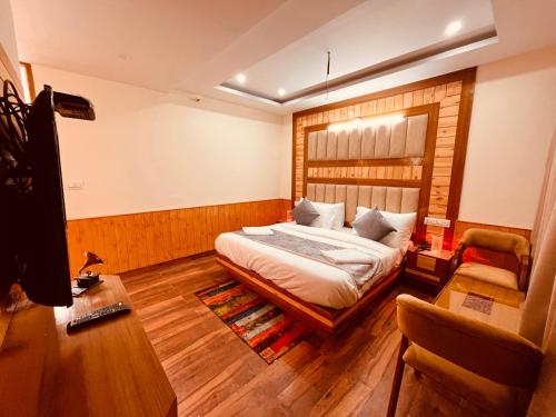 1 dormitorio con 1 cama y 1 silla en Raghav Bro Stays, en Junagadh