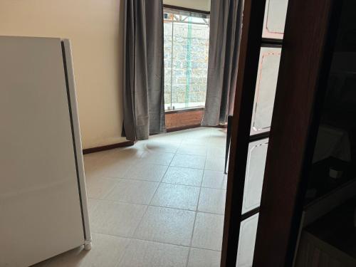 an empty hallway with a door and a window at Chalé 06 com hidro in Itatiaia