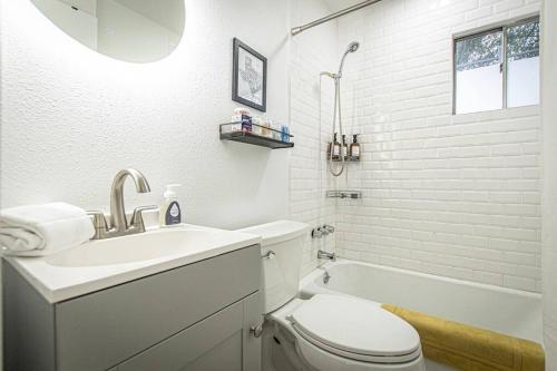 Downtown Austin Suite Retreat في أوستن: حمام مع حوض ومرحاض وحوض استحمام