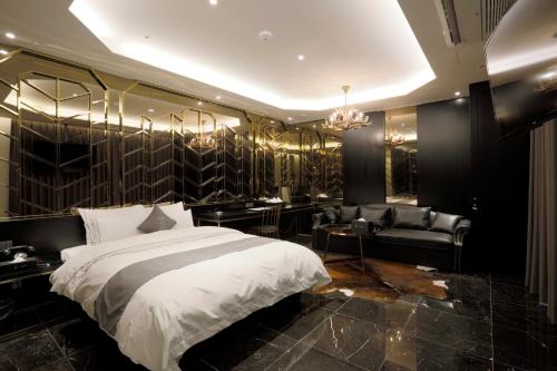 una camera con un grande letto e un divano di Hotel Ischia a Yongin