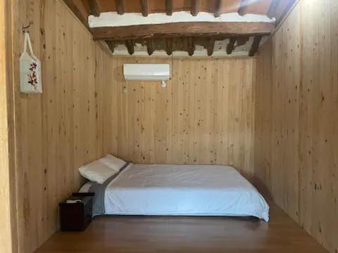 Cette petite chambre comprend un lit dans un mur en bois. dans l'établissement Stay Moon Charm, à Gyeongju