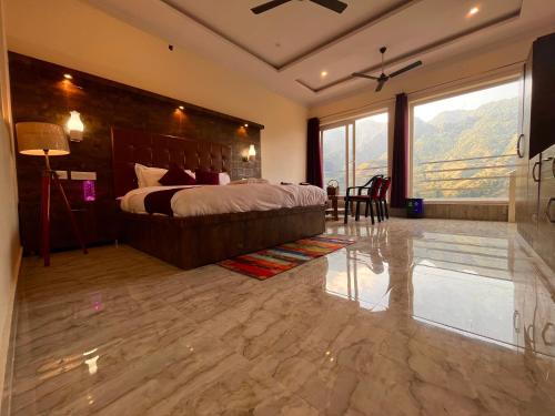 a bedroom with a large bed and a large window at Siluswar Hotel in Junagadh