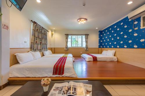 um quarto com 2 camas, uma janela e uma mesa em Yishin Garden B&B em Pinghe