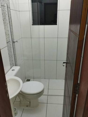 een witte badkamer met een toilet en een wastafel bij Kitnet 3 - Estada do Conforto in Guaíra