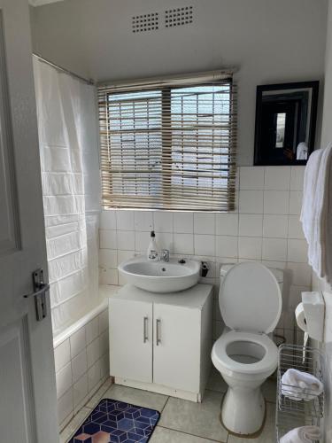 biała łazienka z toaletą i umywalką w obiekcie Vaal Self Catering close to Vaal Mall and Aquadome w mieście Vanderbijlpark