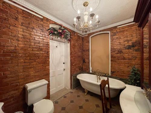 ein Badezimmer mit einer weißen Badewanne und einem Spiegel in der Unterkunft THE RED HOUSE in Niagara Falls