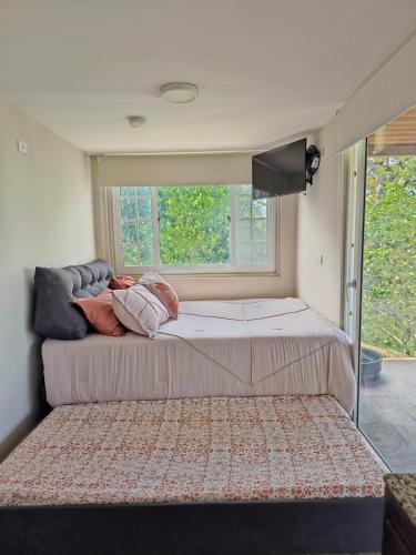 a large bed in a room with a window at Aldayah Tiny Village in Bajo Boquete