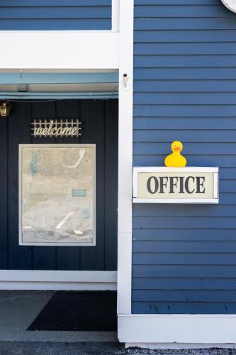 PittsfieldにあるClear River Inn and Tavernの青い建物の側面にあるオフィスの看板