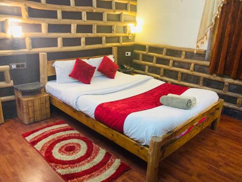 a bedroom with a large bed with red pillows at Swastik Royal Lodge in Junagadh