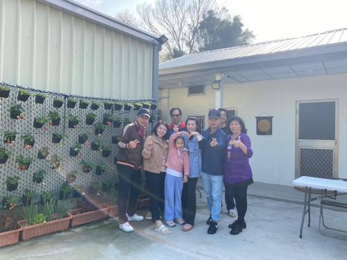 a group of people posing for a picture in front of a house at 佳林居 in Dahu