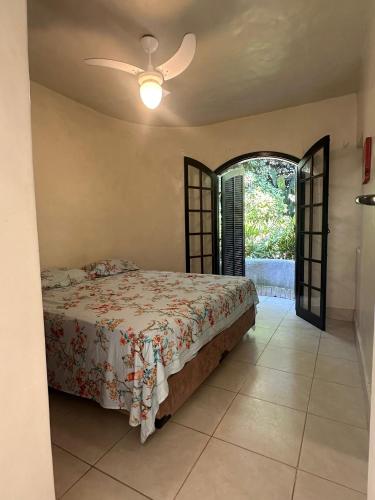 a bedroom with a bed and a ceiling fan at Tenório Beach Hostel 400 MTS da praia do Tenório in Ubatuba