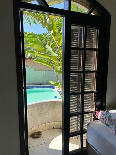 a view of a swimming pool through a glass door at Tenório Beach Hostel 400 MTS da praia do Tenório in Ubatuba