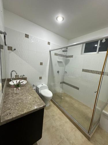 La salle de bains est pourvue d'une douche en verre et de toilettes. dans l'établissement Villa Diana-Condominio campestre, à Girardot