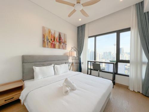 a bedroom with a white bed with a large window at Lucentia Residences BBCC at Lalaport Kuala Lumpur by Veedu Hauz in Kuala Lumpur