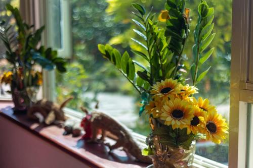 a vase filled with yellow flowers on a window sill at Yishin Garden B&B in Pinghe