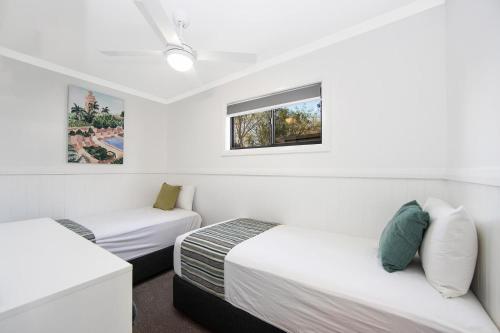 a room with two beds and a window at Ingenia Holidays Soldiers Point in Soldiers Point