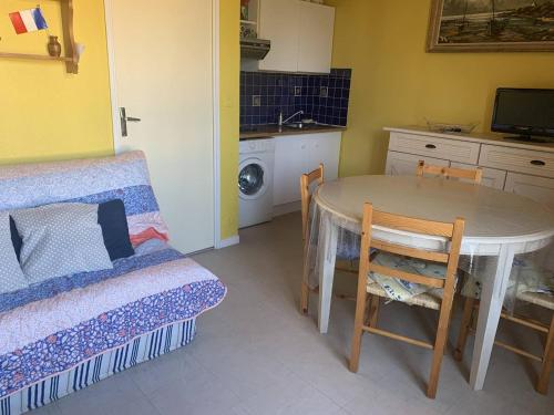 une petite pièce avec une table et une cuisine dans l'établissement Duplex cosy 4 personnes avec parking, proche plage - Merville Franceville - FR-1-465-112, à Merville-Franceville-Plage