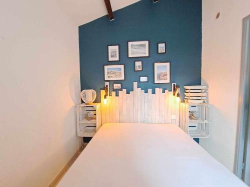 une chambre avec une table et un mur bleu dans l'établissement Appartement 2 pièces avec terrasse, climatisation et accès direct plage - FR-1-326-822, à Marseillan