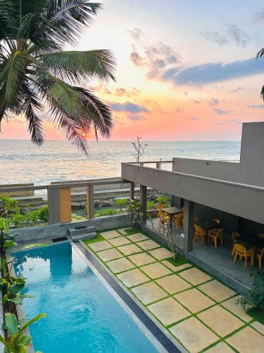 a house with a swimming pool next to the ocean at Villa Sea Queen in Ambalangoda