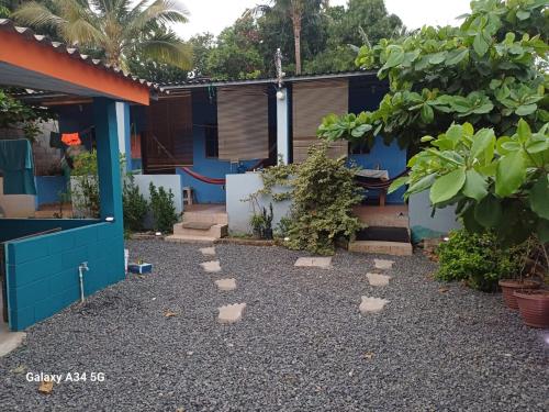 a garden with stepping stones in front of a house at Hostal Niña Oly in Tamanique