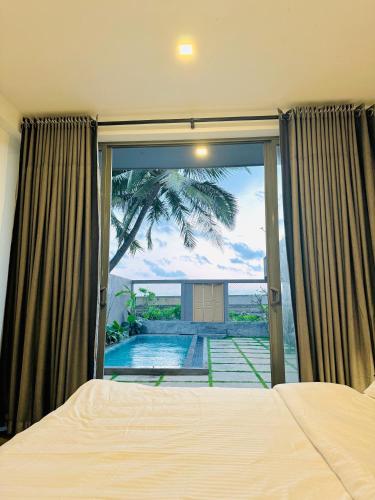 a bedroom with a bed and a view of a pool at Villa Sea Queen in Ambalangoda