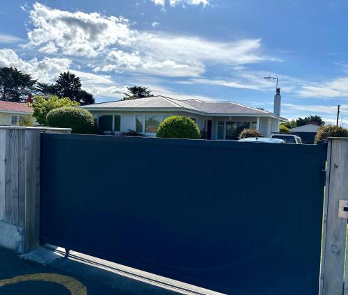 a blue fence in front of a house at Sunny & Cosy Napier Home! in Napier