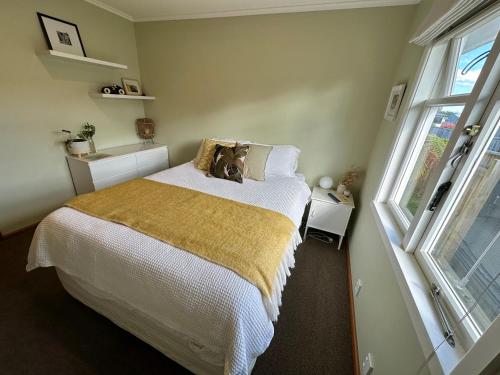 a bedroom with a bed with a teddy bear on it at Sunny & Cosy Napier Home! in Napier