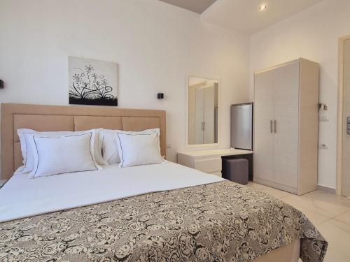 - une chambre avec un grand lit et une télévision dans l'établissement Villa JOSANA, à Saranda