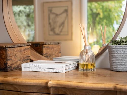 a stack of books sitting on a table with a mirror at Country Oasis With River Views in Cygnet