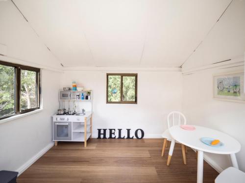 a white room with a table and a kitchen at Country Oasis With River Views in Cygnet