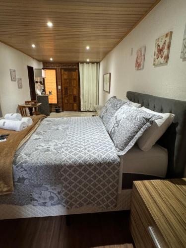 ein Schlafzimmer mit einem großen Bett in einem Zimmer in der Unterkunft Chalé 09 com cozinha no coração de penedo in Itatiaia
